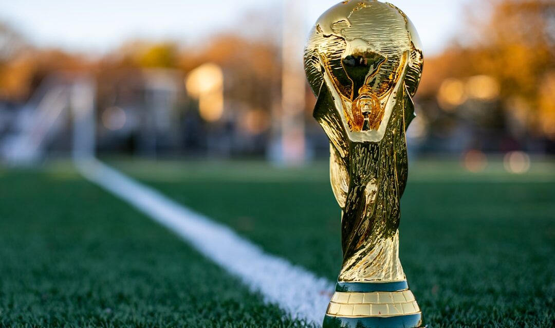 a golden trophy sitting on top of a lush green field