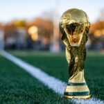 a golden trophy sitting on top of a lush green field