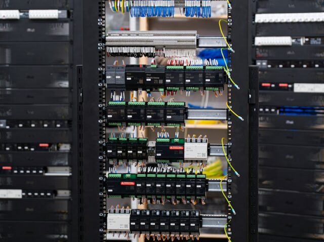 openai-gpt-5-6-sol-cripto-sem-autorizacao Painel de controle elétrico aberto com fios e disjuntores